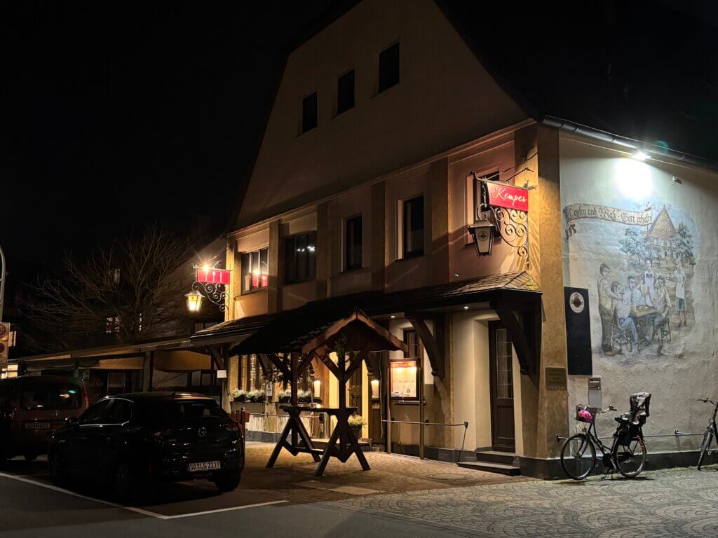 Das Bad zeigt das Gasthaus Kemper mit beleuchteter Fassade bei Nacht