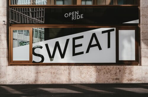 Ausschnittsfoto einer Hauswand. Im Fenster ist die Aufschrift "Sweet" zu sehen. Titelbild für den Beitrag Schweißgebadet in Bad Westernkotten.