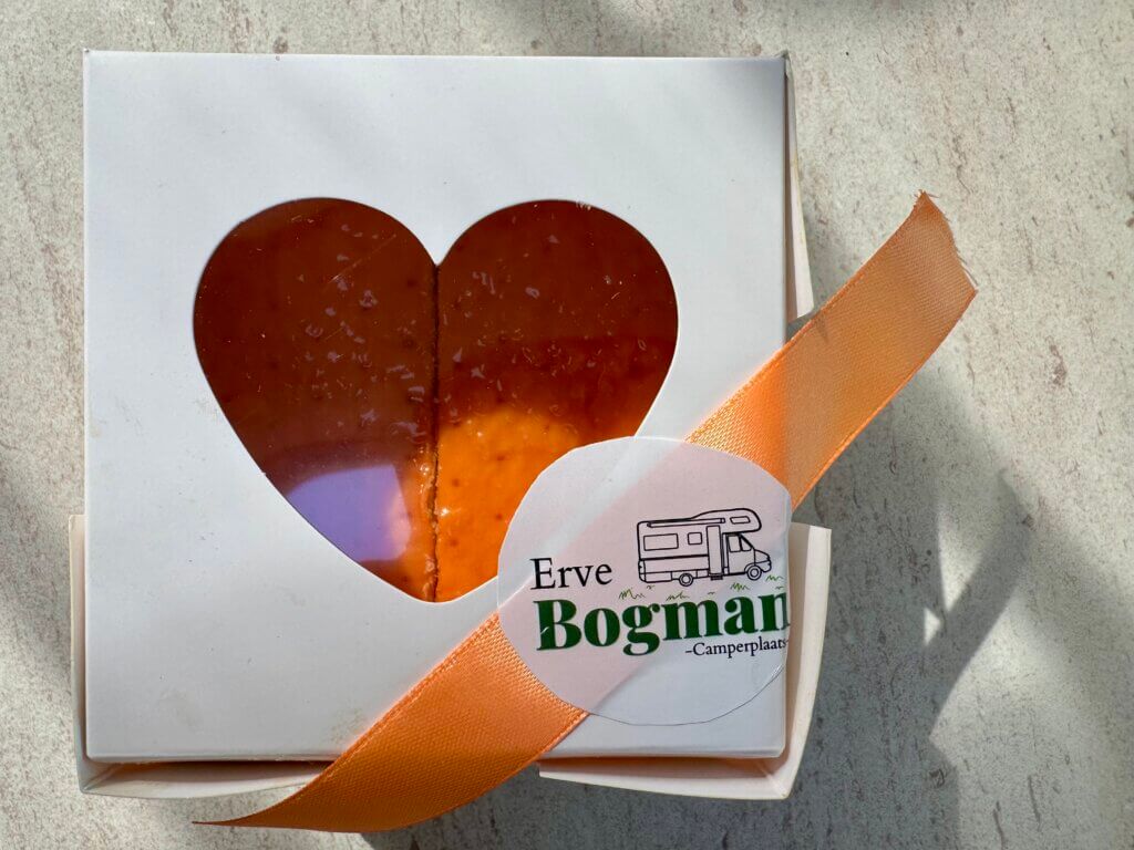 orangener Kuchen in Pappbox. Sichtfenster im Deckel in Herzform