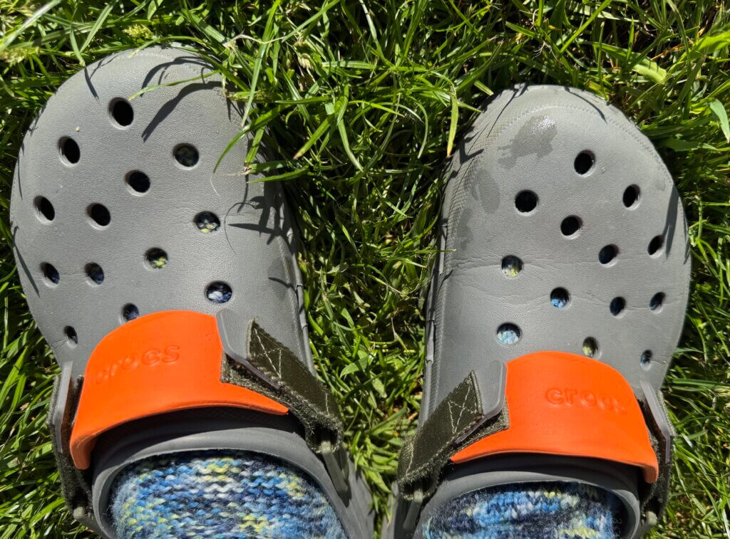 ein paar graue crocs auf rasen