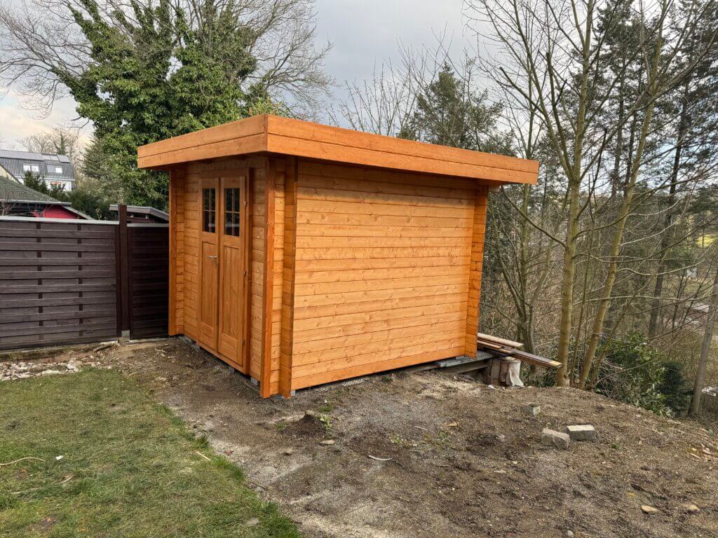 Ein rechteckiges Gartenhaus in Naturfarbe