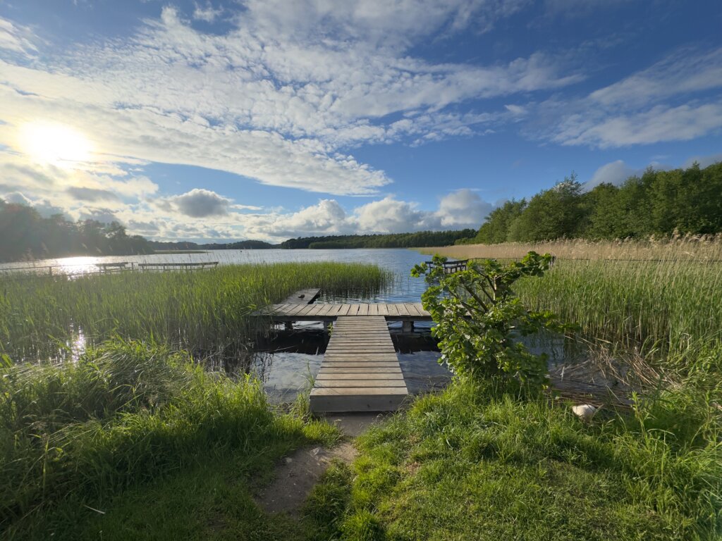 Blick auf den Schaalsee. Im Vordergrund ein Bootssteg. Blauer Himmel mit Wolken