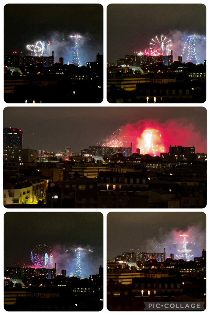 Blick über die Dächer von Paris bei Nacht, im Hintergrund ein großes Feuerwerk über dem Eiffelturm zum französischen Nationalfeiertag am 14. Juli. Farbige Explosionen in Rot, Blau und Weiß leuchten am Himmel, Rauch zieht über die Stadt. Die historische Skyline der französischen Hauptstadt wird von Lichtern und Feuerschein eindrucksvoll in Szene gesetzt.