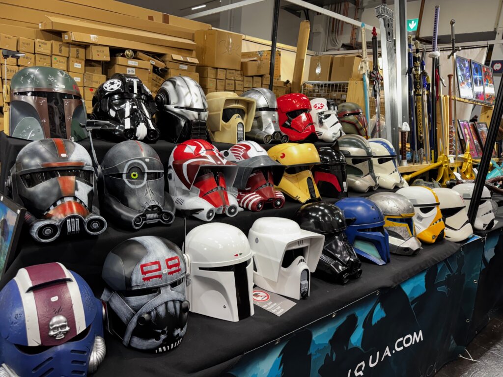 Buntes Sortiment an Sci-Fi-Helmen, inspiriert von Star Wars, ausgestellt auf der SPIEL Essen – von Stormtrooper bis Mandalorianer.