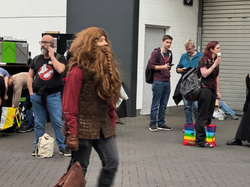 Cosplayer als Zwerg mit mächtigem Bart auf der SPIEL Essen – wartende Messebesucher im Hintergrund.