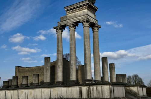 Der rekonstruierte Hafentempel im archäologischen Park Xanten. Die Tempelanlage mit Säulenreihen steht auf einer Plattform vor blauem Winterhimmel.