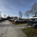 Campingplatz Rumkerhof. Fahrweg mit Wohnmobilen rechts und link. Blick auf das Hauptgebäude im Hintergrund
