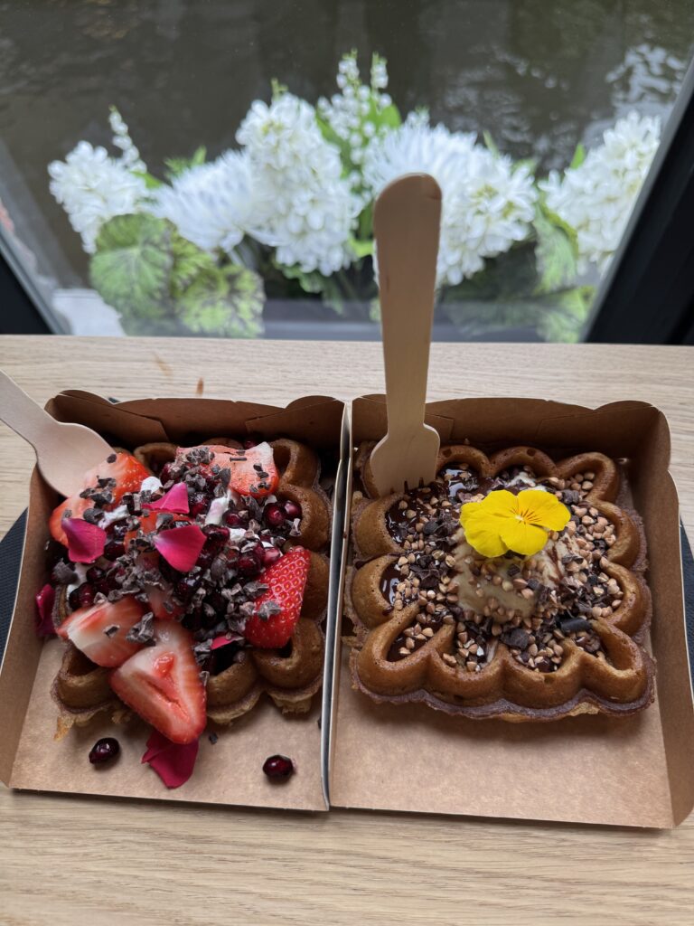 Zwei belgische Waffeln mit Erdbeeren, Schokolade, Nüssen und Blüten in Brügge.
