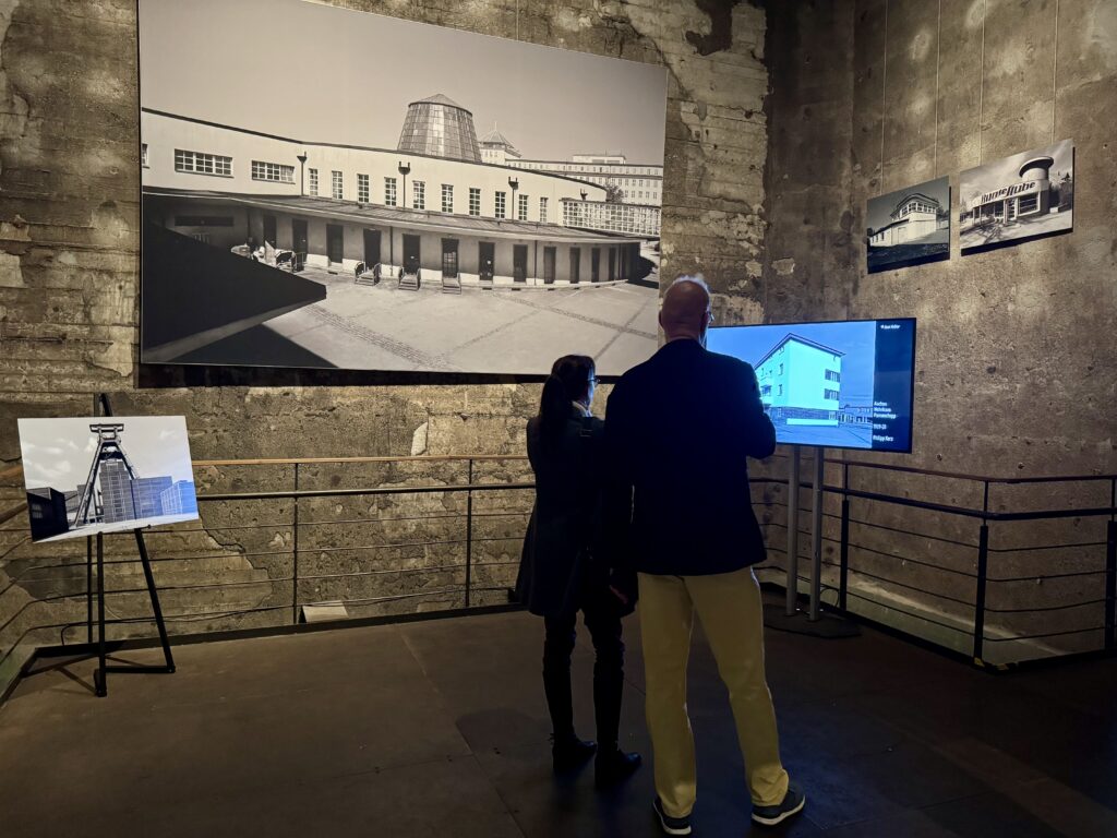 Besucher vor großem Foto und Bildschirm in der Ausstellung.