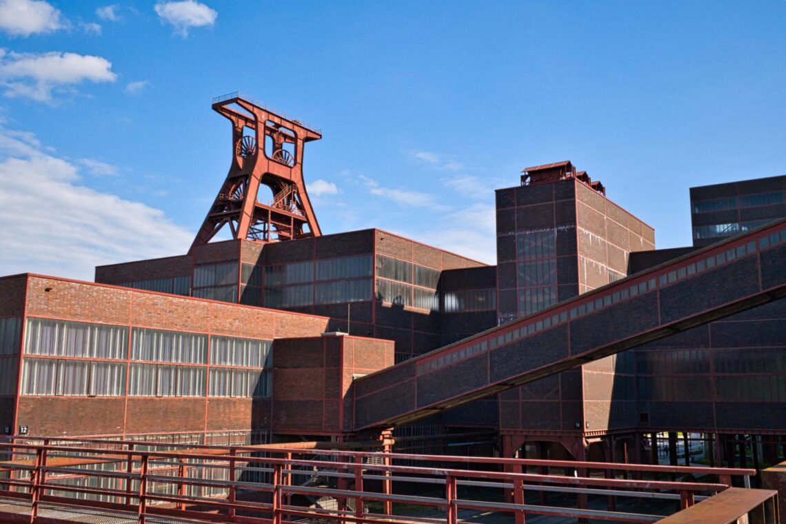 Nahaufnahme von Schacht XII mit Fördergerüst und Architekturachsen.