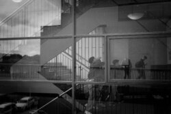 Mehrfachbelichtung mit Treppengeländern und Personensilhouetten, abstrakte Schwarzweiß-Komposition, geometrische Linien und Reflexionen