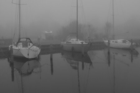 Drei Segelboote liegen im nebligen Hafen von Sneek, im Hintergrund ist ein Wohnmobil zu sehen.