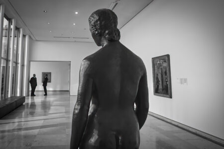 Bronzeskulptur einer nackten Frau von hinten betrachtet, zwei Museumsbesucher im Hintergrund, Folkwang Museum Essen