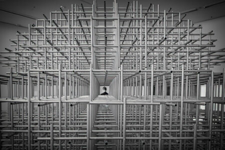 Perspektive durch Metallgitter-Skulptur, symmetrische Konstruktion mit zentraler Fluchtpunkt-Sicht auf Museumsbesucher