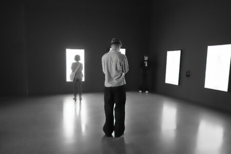 Lichtinstallation mit leuchtenden weißen Rechtecken im dunklen Raum, drei Besucher als Silhouetten, Folkwang Museum