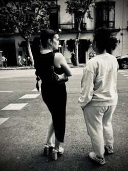 Zwei Personen von hinten an einem Zebrastreifen in einer belebten Stadtstraße, Schwarzweiß-Streetfotografie Sevilla