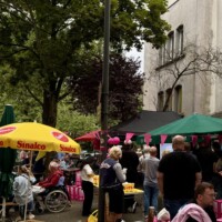 Straßenszene mit Besuchern, Hund und Sinalco-Sonnenschirm vor einem Kiosk beim Tag der Trinkhallen in Rüttenscheid
