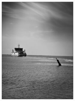 Fähre passiert eine Fahrwassertonne auf ruhiger See, weite Himmelsfläche mit Wolkenschlieren, Schwarzweiß-Seefotografie